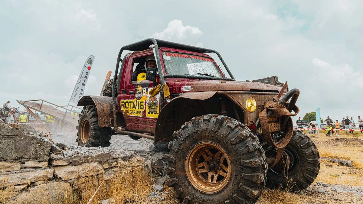 A powerful off-road vehicle conquers rocky terrain during a thrilling outdoor race event.