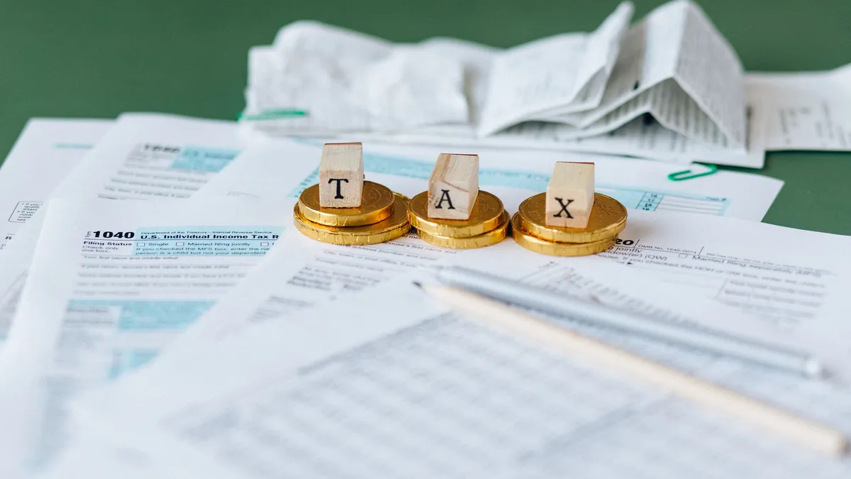 Close-up of tax forms, receipts, and coins symbolizing financial accounting and taxes.