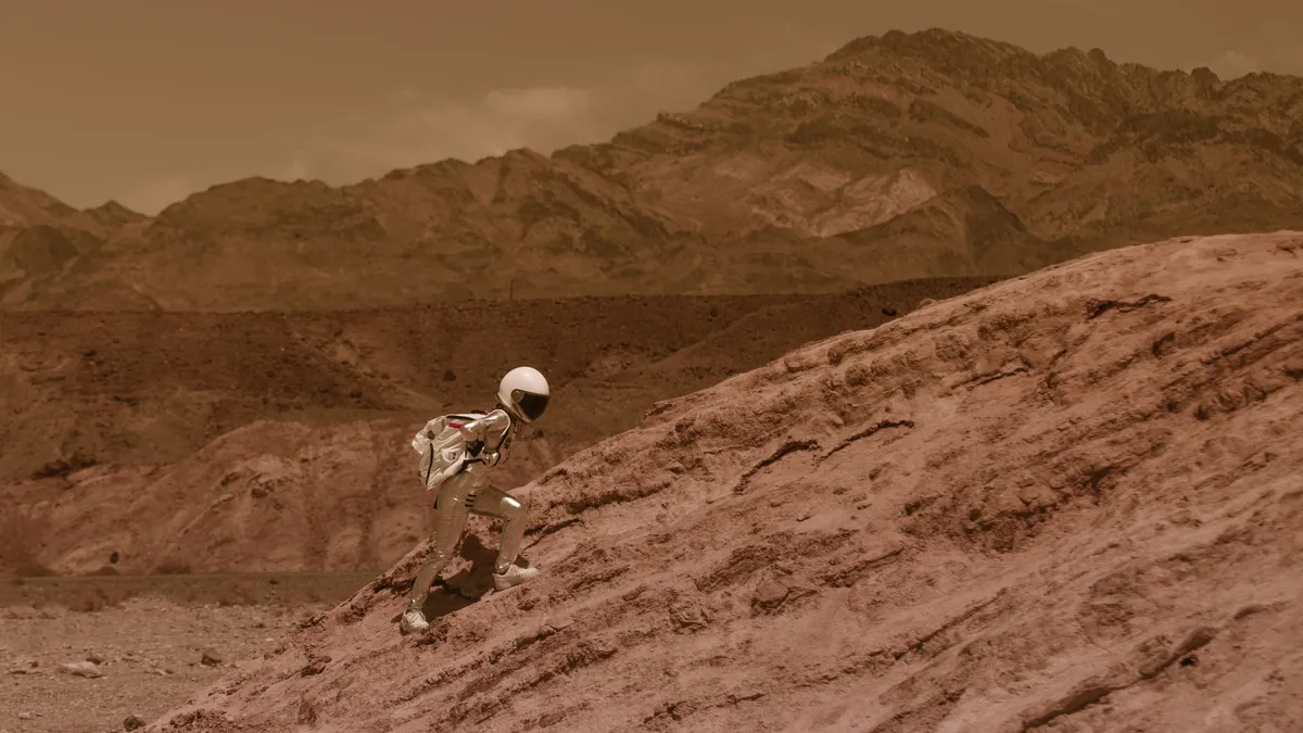 Astronaut in a spacesuit explores a desert-like environment with rocky formations. — Photo by RDNE Stock project on Pexels