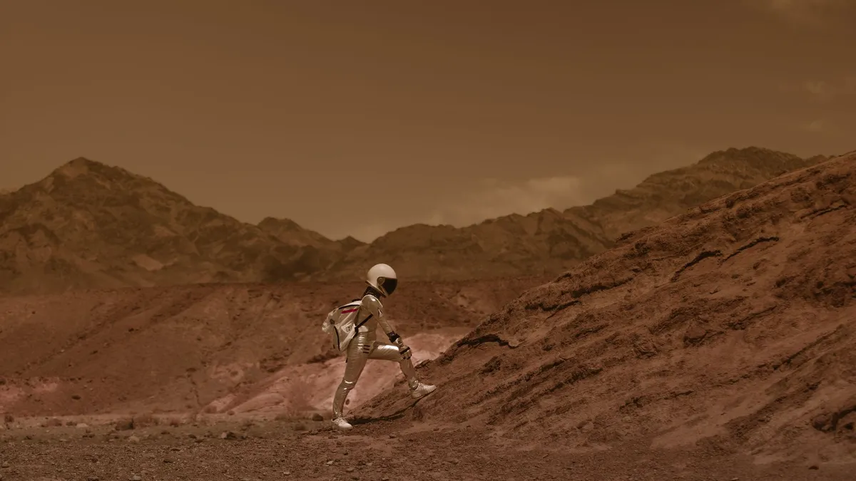 Astronaut in space suit walking through a Mars-like desert landscape, highlighting exploration and adventure. — Photo by RDNE Stock project on Pexels